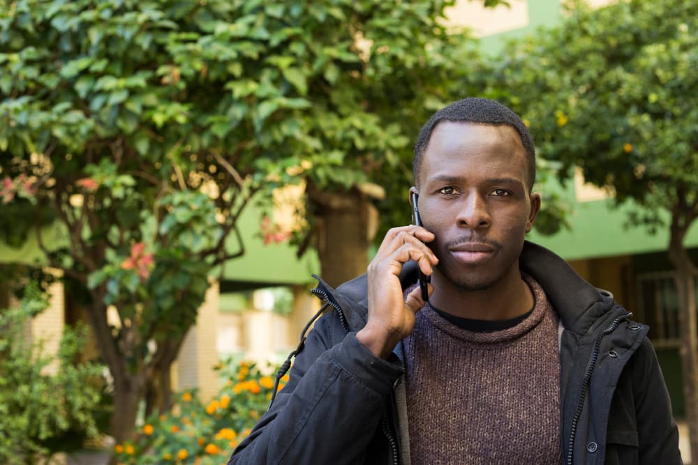 A buyer standing outside a property on the phone